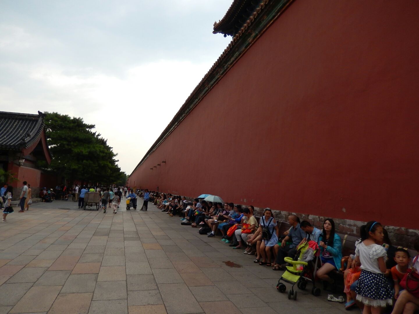 Exhausted crowds taking a break in a shady lane inside the Forbidden City.
