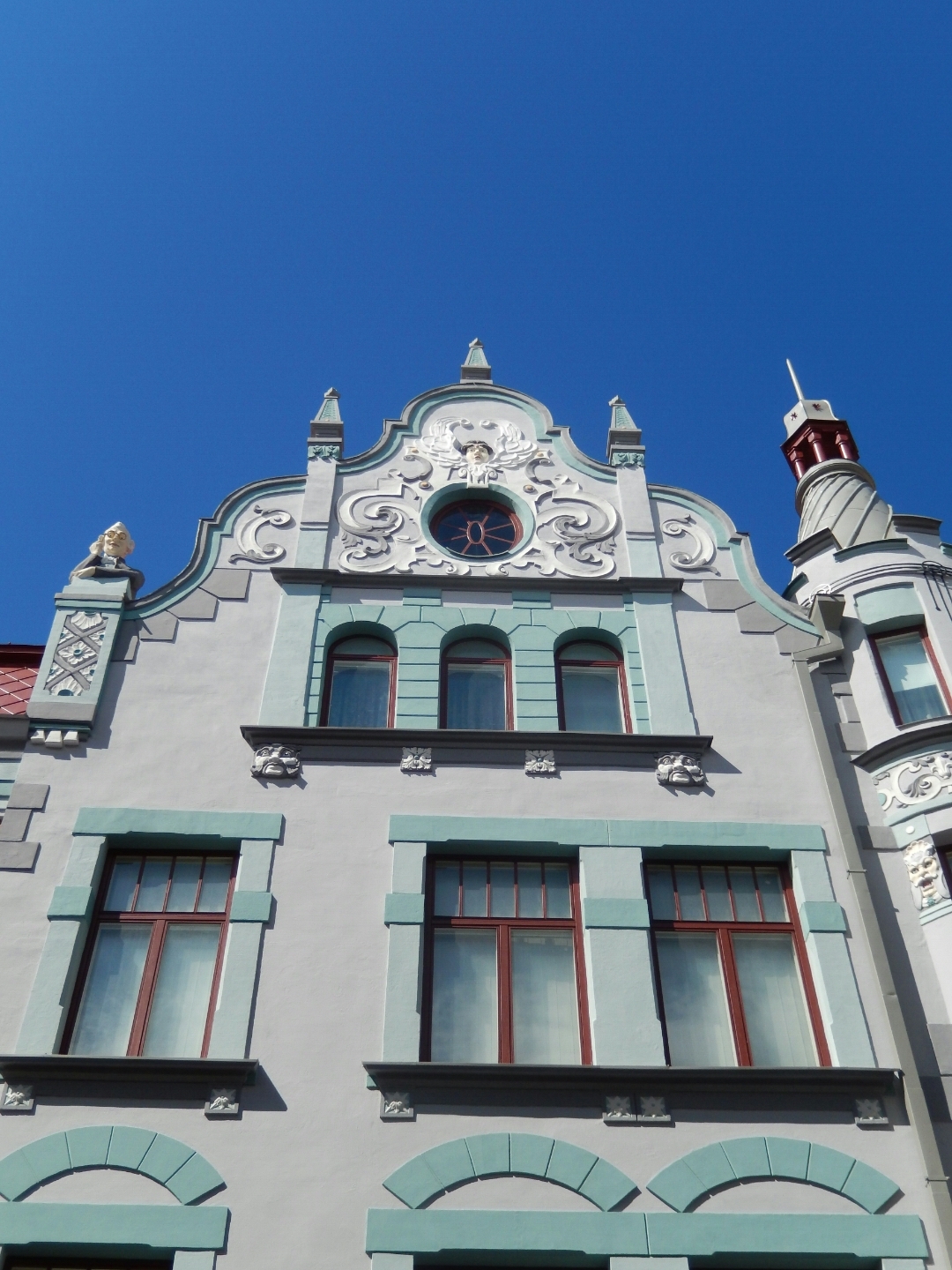 Interesting house with unusual spiral tower in the background and bust on one of the pillars...
