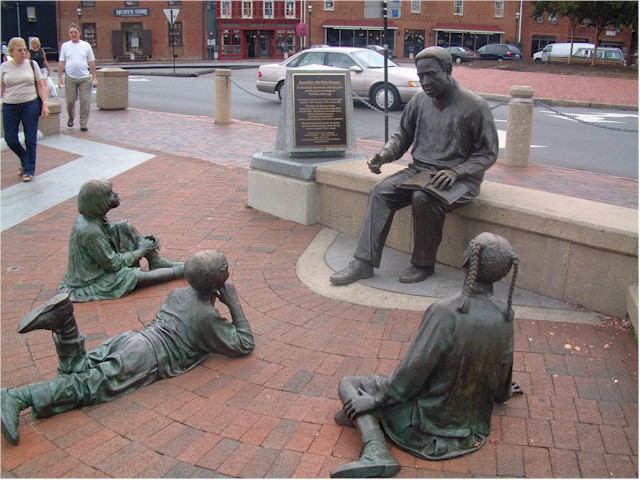 This delightful sculpture represents Alex Haley reading his "Roots" book to attentive children.
