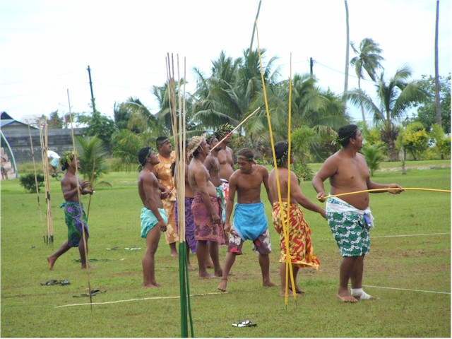 
Locals throwing spears at a coconut high on a pole.