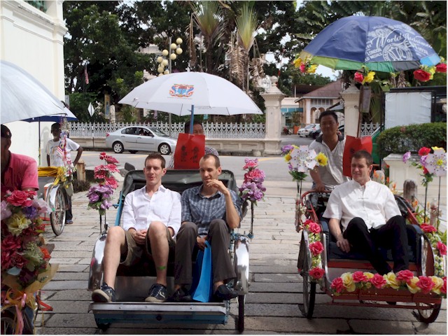 Wedding day at last - and the groom and his entourage arrive at the Mansion by trishaw.
