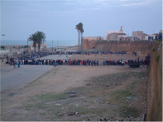 An exciting game of soccer attracts the local crowd.